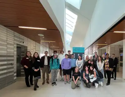 Group of volunteers and students around Junior Achievement Banner